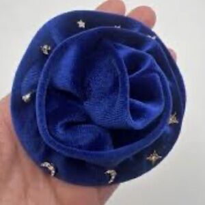 Free People blue rosette brooch packaged with gold-tone stud earrings.